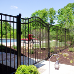 Ornamental steel pool fence with smooth arched gate installed by Struck & Irwin Fence, meeting Wisconsin pool safety standards.